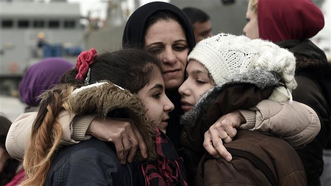 A Syrian Kurd originally from Aleppo hugs her daughters as they are reunited after being separated while crossing from Turkey to Greece