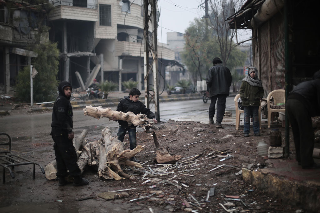 Two boys collect tree branches to make fire wood in Kafar Batna village in Rural Damascus Syria