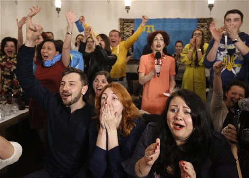 People celebrate while watching TV as Jamala of Ukraine wins the final of the Eurovision Song Contest in Stockholm in a restaurant in Kiev Ukraine Sunday