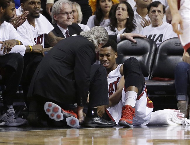 Miami Heat center Hassan Whiteside is attended by a team member after he was injured during the first half of Game 3 of an NBA second-round playoff basketball series against the Toronto Raptors Saturday