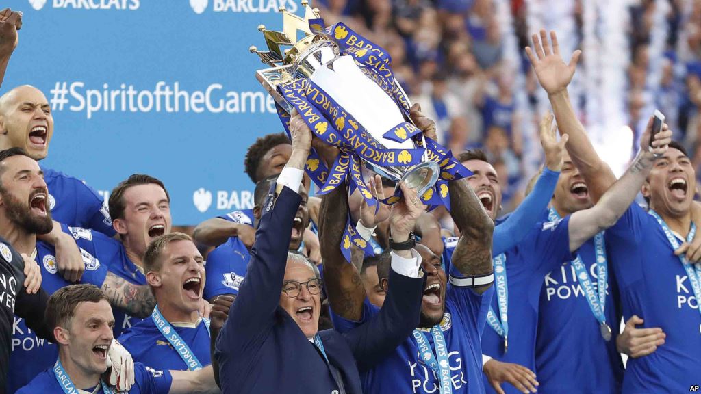 Leicester team manager Claudio Ranieri and Wes Morgan lift the trophy as Leicester City celebrates becoming the English Premier League soccer champions at King Power Stadium in Leicester England