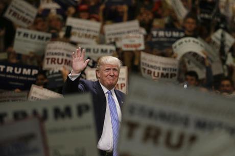 Republican presidential candidate Donald Trump waves to the crowd as he arrives at a rally at the Anaheim Convention Center Wednesday