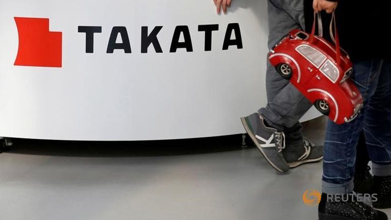 Visitors walk past a logo of Takata Corp on its display at a showroom for vehicles in Tokyo Japan