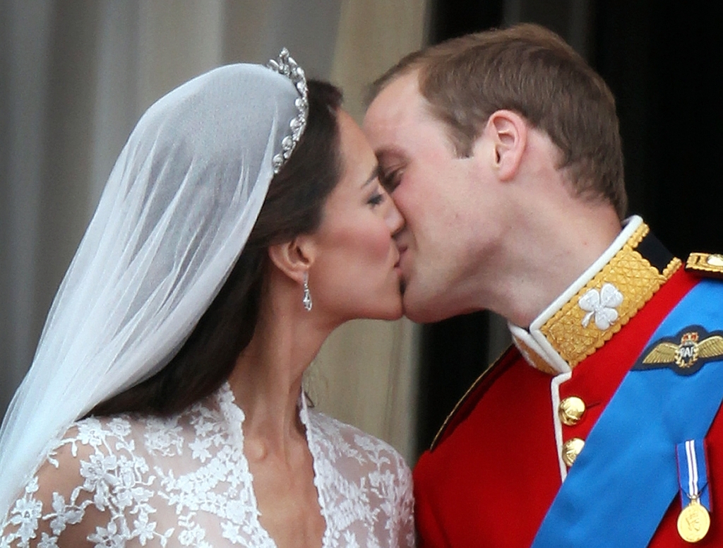 Their Royal Highnesses Prince William Duke of Cambridge and Catherine Duchess of Cambridge kiss on the balcony at Buckingham Palace