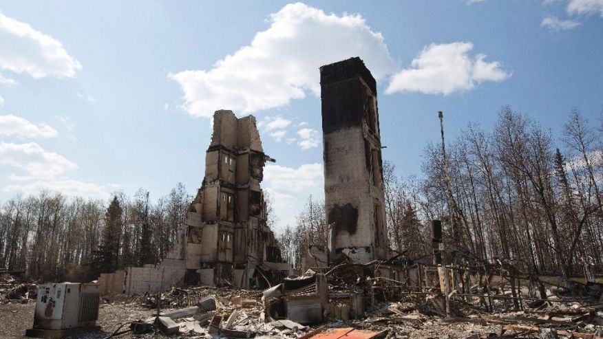 A burned building stands among charred rubble in the neighborhood of Abasand in wildfire-ravaged Fort McMurray Alberta on Friday