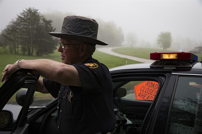 Deputy Sheriff Michael Creamer of the Pickaway County Sheriff's Office stands guard beside a police roadblock on Union Hill Road at the outer perimeter of a crime scene Wednesday