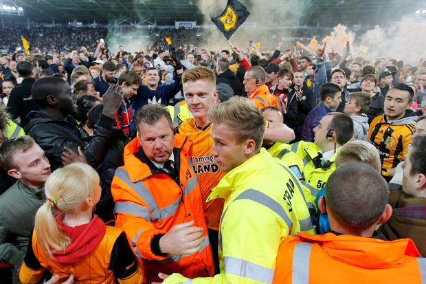 Clucas the Hull midfield player is escorted off as fireworks explode behind him
PA:Press Association