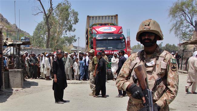 A Pakistani soldier stands guard as a truck enters Pakistan from Afghanistan at the border crossing in Torkham