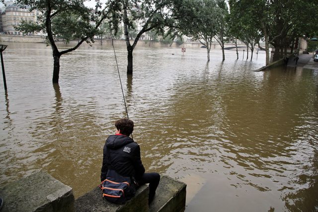 A boy fishes in the flooded Seine in Paris on Sunday. AP