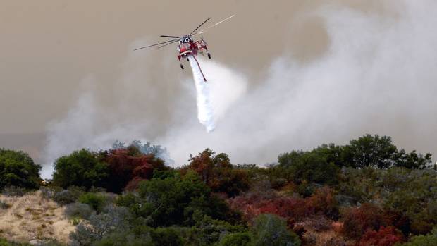 A helicopter joins the effort against a wildfire in Santa Barbara County