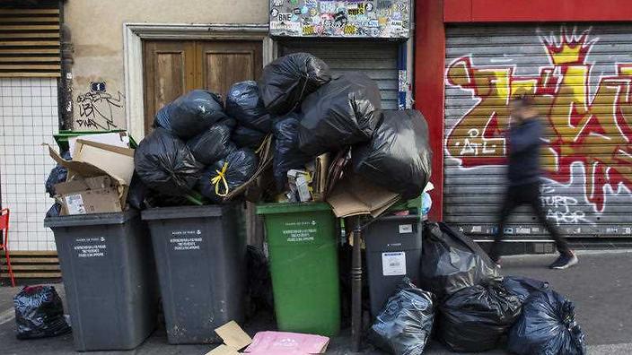 A man walks past a pile of rubbish bags in Paris France Wednesday