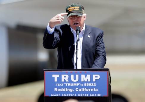 Donald Trump gestures to a his camouflaged ‘Make America Great’ hat as he discuses his support by the National Rifle Association at a campaign rally in Redding California at the weekend