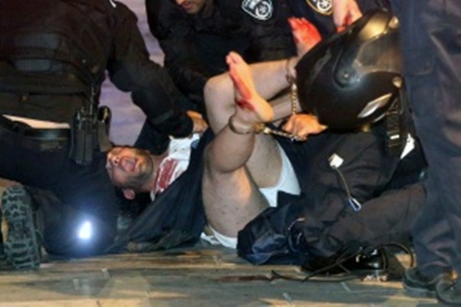 Israeli policemen arrest a suspected man following a shooting attack that took place in the center of Tel Aviv