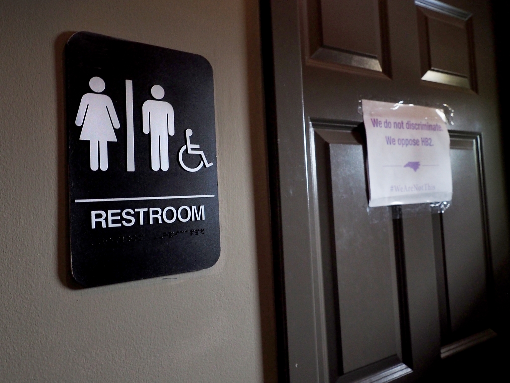 A unisex sign and the'We Are Not This slogan are outside a bathroom at Bull Mc Cabes Irish Pub