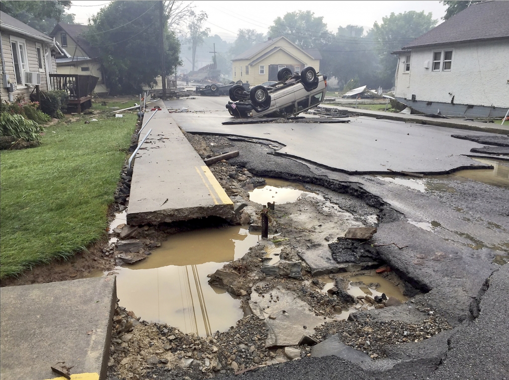 A vehicle rests on the roof after flooding near White Sulphur Springs