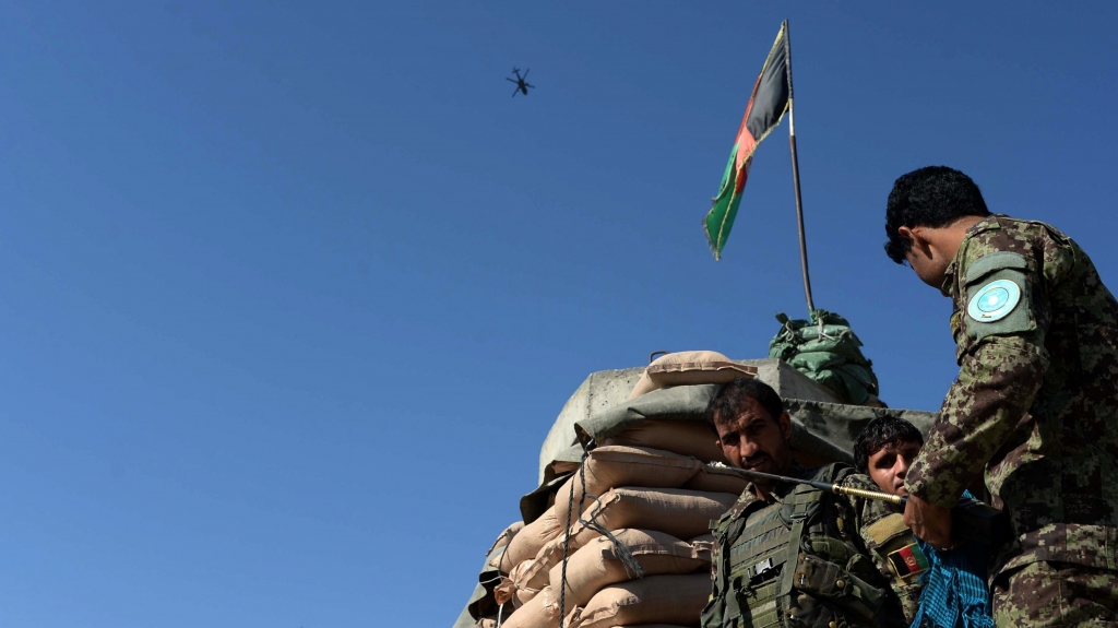 Afghan National Army soldiers stand guard as a U.S. helicopter flies over Jalalabad Airport on Oct. 2 2015