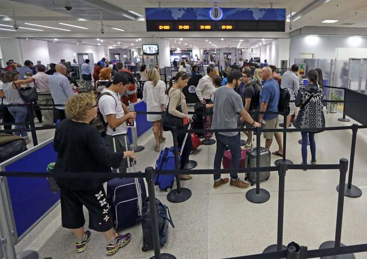 Alan Diaz 
 

 
Travelers stand in line to pass through a TSA checkpoint at Miami International Airport on Thursday