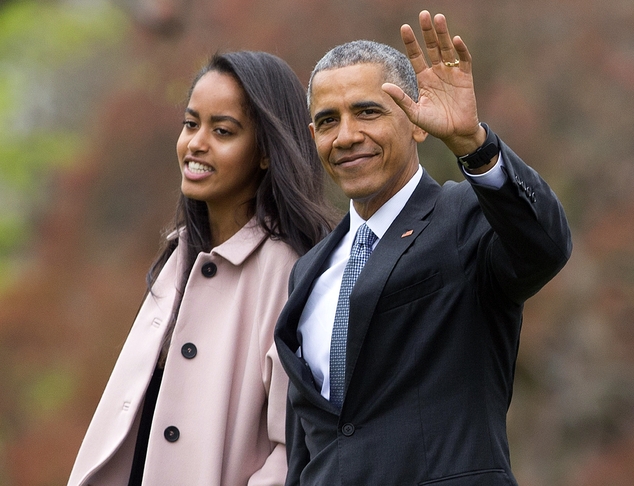 President Barack Obama and his daughter Malia walk across the South Lawn of the White House in Washington before