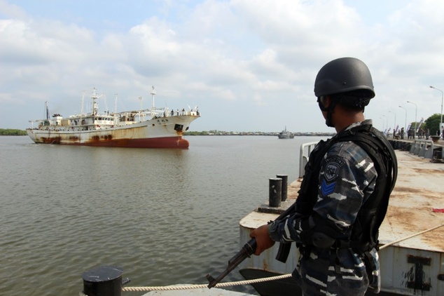 An Indonesian Navy officer in April standing before a Chinese trawler that was allegedly operating illegally