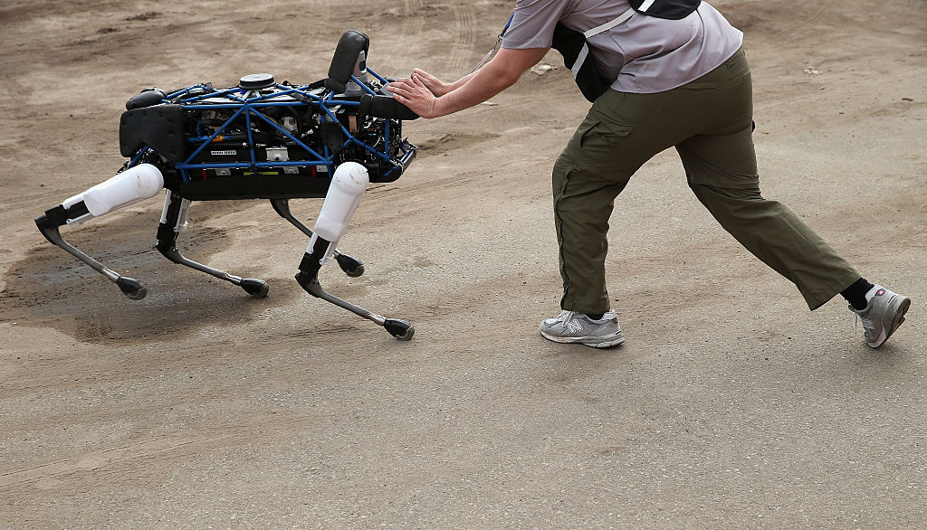 An operator attempts to push over one of Boston Dynamics&#039 Spot robot