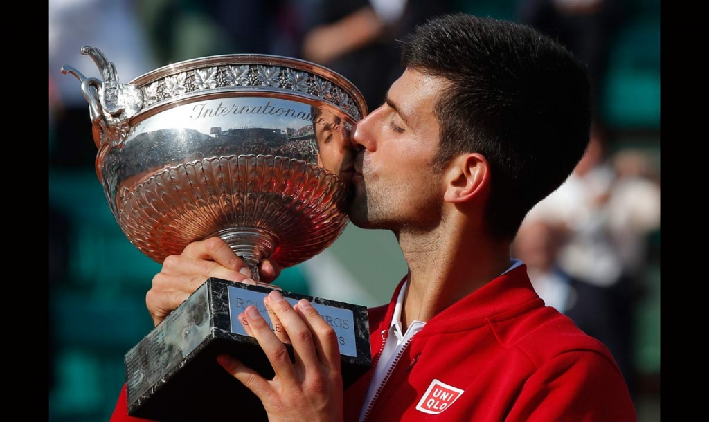 Serbia's Novak Djokovic kisses the trophy after winning the final of the French Open tennis tournament against Britain's Andy Murray in four sets 3-6 6-1 6-2 6-4 at the Roland Garros stadium in Paris France Sunday