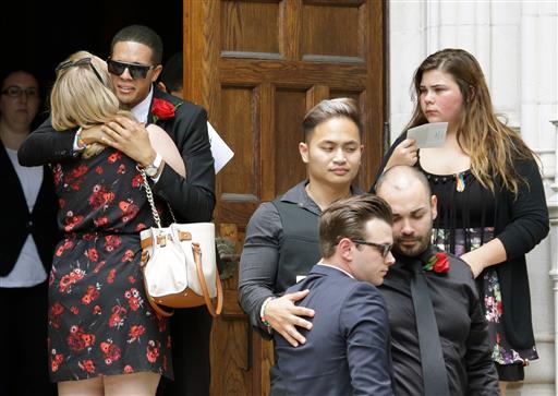 Mourners embrace and gather outside following the funeral service for Christopher Andrew Leinonen one of the victims of the Pulse nightclub mass shooting outside the Cathedral Church of St. Luke Saturday