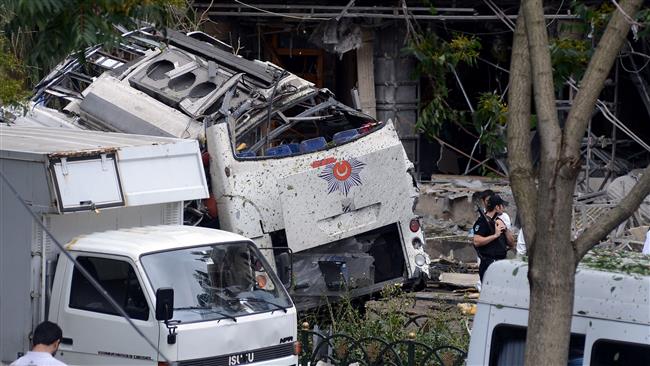 A Turkish anti riot-police officer stands guard near the site of a bomb attack that targeted a bus shuttle service carrying anti-riot police in the Beyazit district of Istanbul