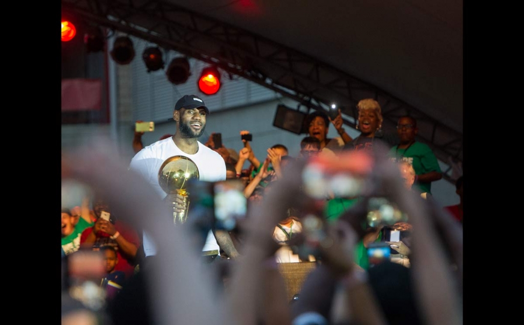 LeBron James steps on-stage with the NBA basketball championship trophy during his hometown celebration in Akron Ohio Thursday