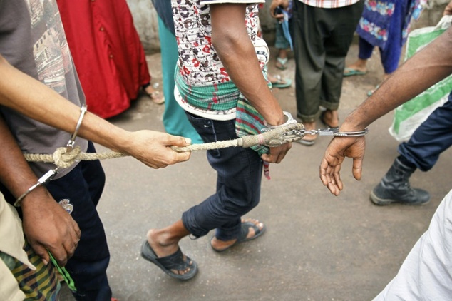 Bangladeshi police escort arrested men in Dhaka on Sunday who were detained during a anti-militant crackdown across the country. — AFP