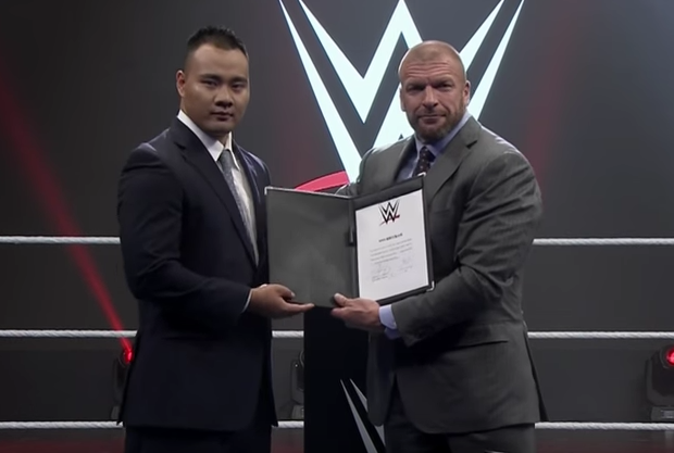 Bin Wang with Triple H after signing his