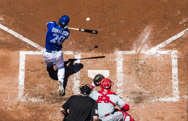 Toronto Blue Jays Josh Donaldson hits a grand slam home run as Philadelphia Phillies catcher Cameron Rupp watches for the ball during the third inning of MLB Interleague baseball action in Toronto Tuesday