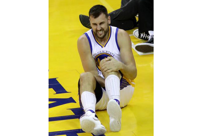 Andrew Bogut of the Golden State Warriors holds his knee in pain after sustaining an injury during the third quarter against the Cleveland Cavaliers in Game 5 of their 2016 NBA Finals in Oakland California Monday. — AFP