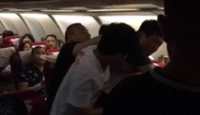 Mass brawl erupts onboard flight as passenger lashes out at cabin crew after four-hour delay