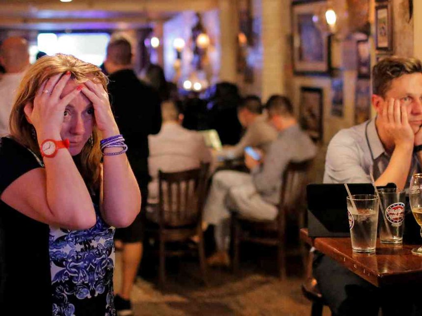 People gathered in The Churchill Tavern a British themed bar react as the BBC predicts Briatin will leave the European Union in the Manhattan borough of New York U.S