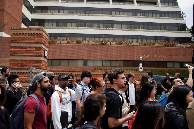 Students walk past the engineering building as they leave campus after police officers conducted a search at the University of California Los Angeles campus after it was placed on lockdown following reports of a shooter that left 2 people dead