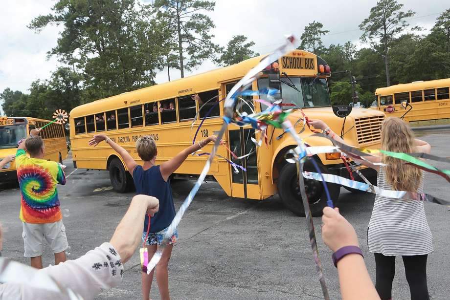 Teachers at White Oak Elementary School in Carteret NC. wave goodbye to their students on the last day of school as they depart for summer vacation. An Education Department report found 6.5 million students nationwide were chronically absent