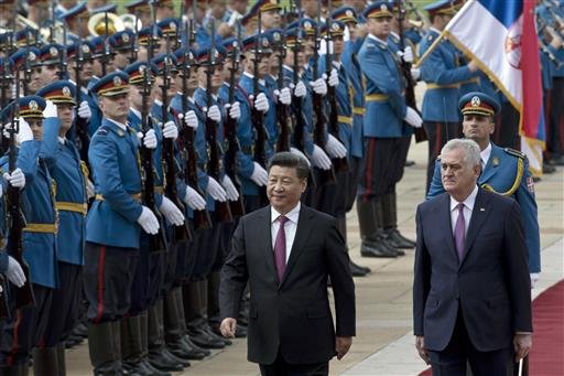 Chinese President Xi Jinping center and his Serbian counterpart Tomislav Nikolic right walk past Serbian army Honor Guards during a welcoming ceremony in Belgrade Serbia Saturday