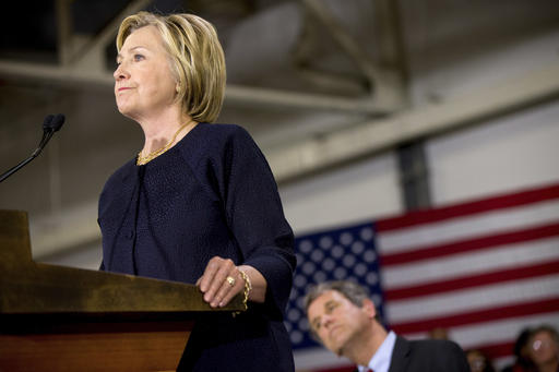 Democratic presidential candidate Hillary Clinton left accompanied by Sen. Sherrod Brown D-Ohio right speaks at a rally at a warehouse for the company'Team Wendy which produces helmets for military law enforcement and rescue teams in Cleveland