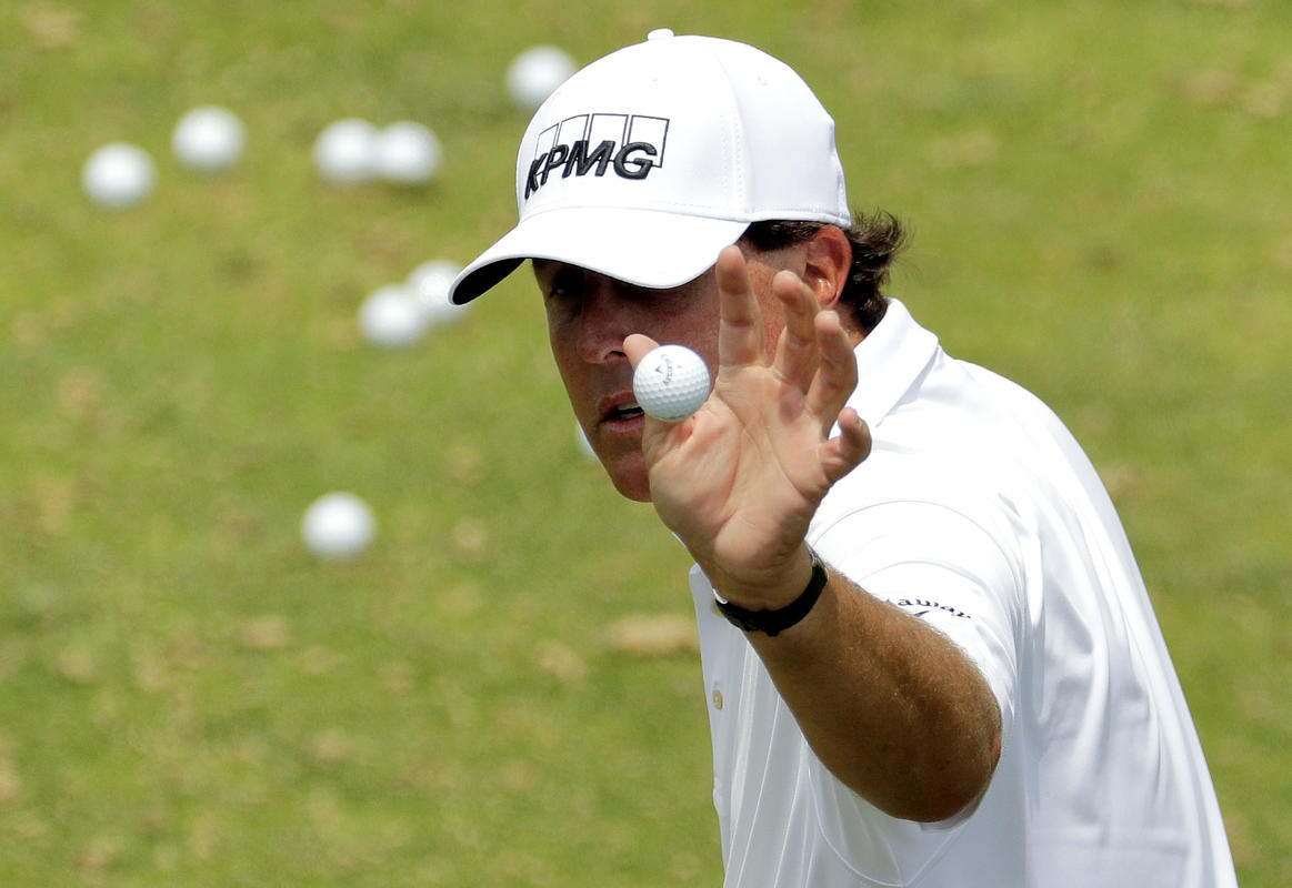 Phil Mickelson catches a ball from his caddie before his practice round yesterday at Oakmont Country Club