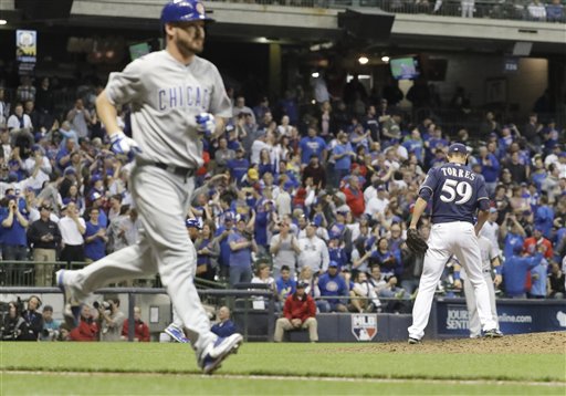 Milwaukee Brewers relief pitcher Carlos Torres sands on the mound as Chicago Cubs&#039 Travis Wood walks to first during the 13th inning of a baseball game Wednesday