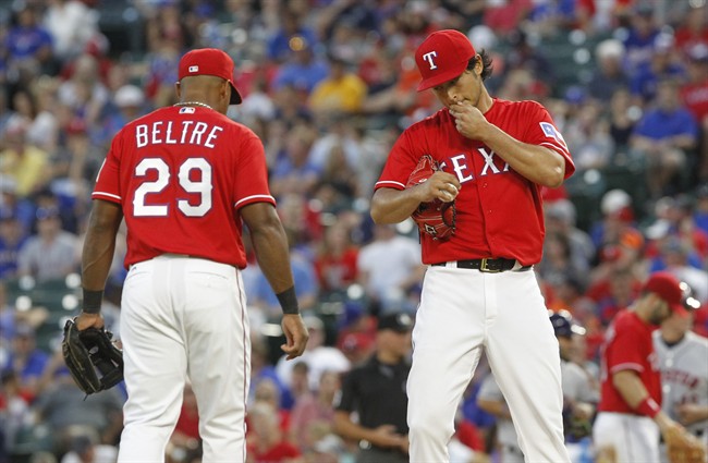 Texas Rangers third baseman Adrian Beltre visits pitcher Yu Darvish on the mound during the fifth inning of a baseball game against the Houston Astros on Wednesday