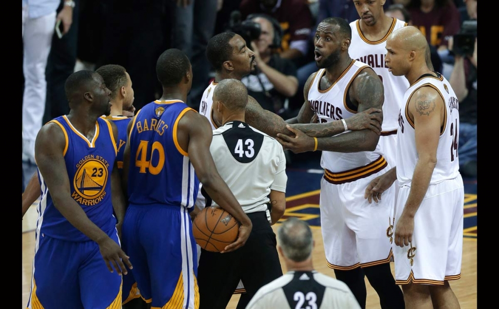 Cleveland Cavaliers forward Le Bron James is held back as he argues with Golden State Warriors forward Draymond Green during the second half of Game 4 of basketball's NBA Finals in Cleveland Friday