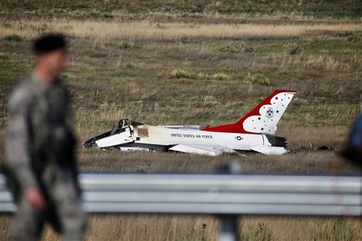 An Air Force security officer guards the site where a U.S. Air Force Thunderbird crashed following a flyover performance at a commencement for Air Force Academy cadets south of Colorado Springs Colo. Thursday