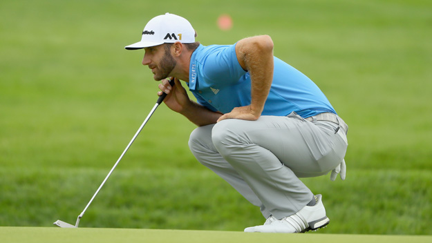 Dustin Johnson looks over a putt on the first green at the U.S. Open