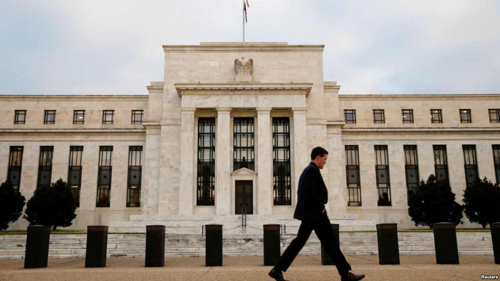 FILE- A man walks past the Federal Reserve Bank in Washington D.C