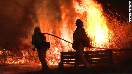 Firefighters approach a brush in the foothills outside of Calabasas California on Saturday