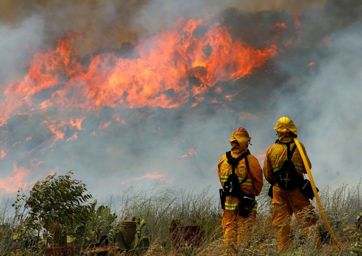 Firefighters from Chino Hills keep watch on a wildfire as they perform structure protection on a residence near Potrero California