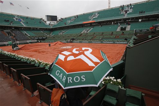 A few spectators wander around on center court of the French Open tennis tournament at the Roland Garros stadium in Paris France Monday