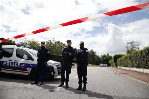 French police officers block the road leading to a crime scene the day after a knife-wielding attacker stabbed to death a senior police officer and his female companion Monday evening in Magnanville west of Paris France Tuesday