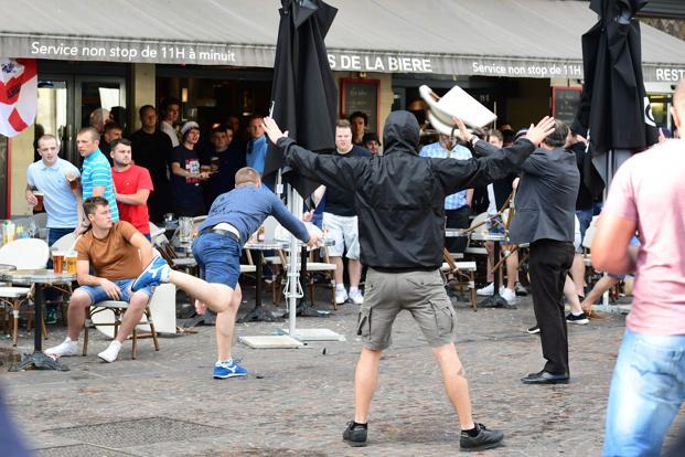 A Russian football supporter lobs a chair towards Slovakian fans sitting in a cafe in the northern city of Lille on 14 June 2016 the day before the Euro 2016 match Russia vs Slovakia at the Pierre Mauroy stadium in the city